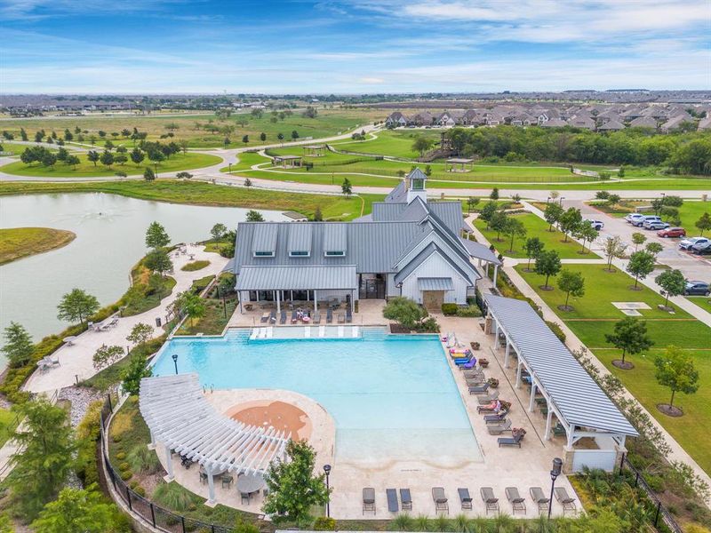 The Sandbrock Ranch community pool complex offers a resort-style amenity featuring an infinity-edge pool, a beach entry, sun shelf seating & an adjacent splash pad. Located at the Carriage House amenity center, the pool overlooks fishing lakes & includes shaded lounging areas, making it a hub for resident relaxation & recreation. The Sandbrock Ranch community pool complex offers a resort-style amenity featuring an infinity-edge pool, a beach entry, sun shelf seating & an adjacent splash pad. Located at the Carriage House amenity center, the pool overlooks fishing lakes & includes shaded lounging areas, making it a hub for resident relaxation & recreation.