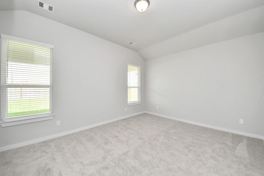 Escape to tranquility in this spacious primary room, adorned with plush carpeting and bathed in the soothing hues of warm paint colors, creating a cozy retreat for relaxation. Sample photo of completed home with similar floor plan. Actual colors and selections may vary.