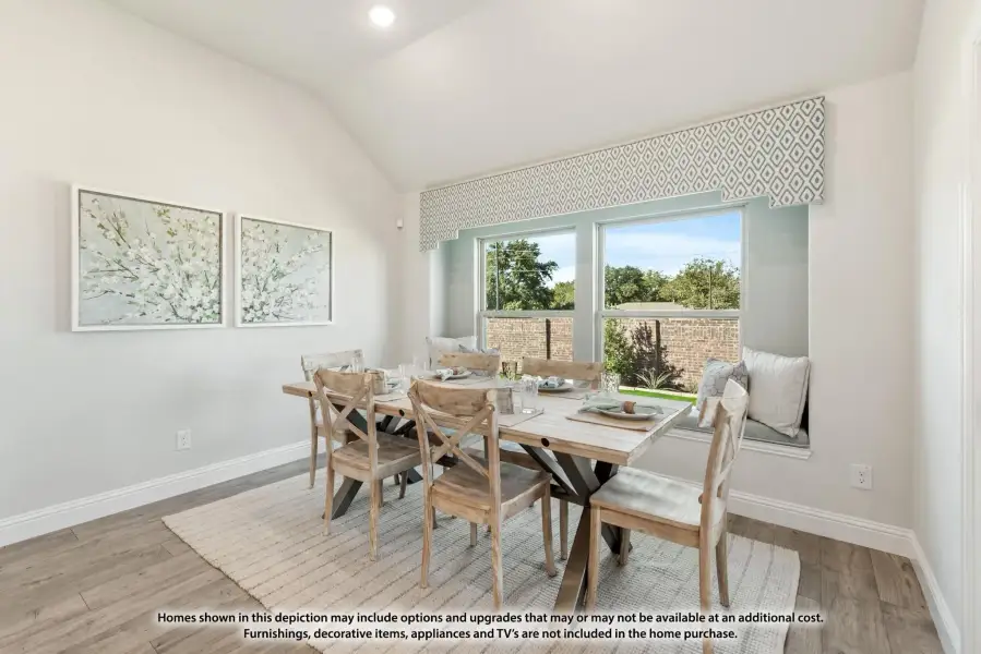Dining room with vaulted ceiling, wood table, six chairs, window seat, and large window with outdoor view.