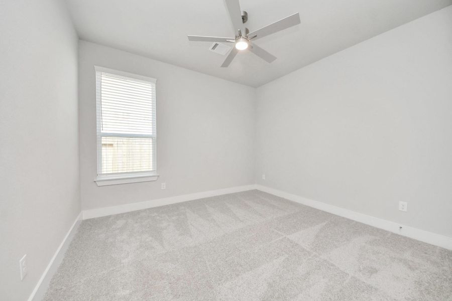Secondary bedroom features plush carpeting, large windows that let in plenty of natural light, bright paint, and spacious closets. Sample photo of completed home with similar floor plan. Actual colors and selections may vary.