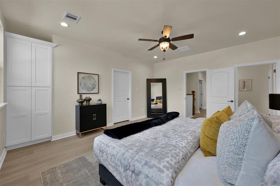 Another view of the primary bedroom with built ins and ensuite bath beyond.