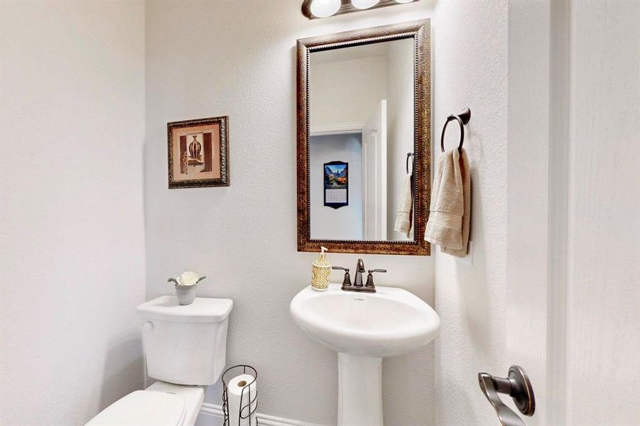 Half bath featuring toilet and a textured wall