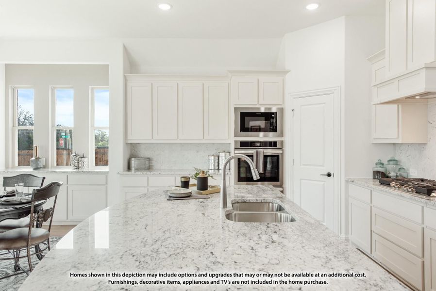 White kitchen with granite island, stainless steel double oven, and white shaker cabinets