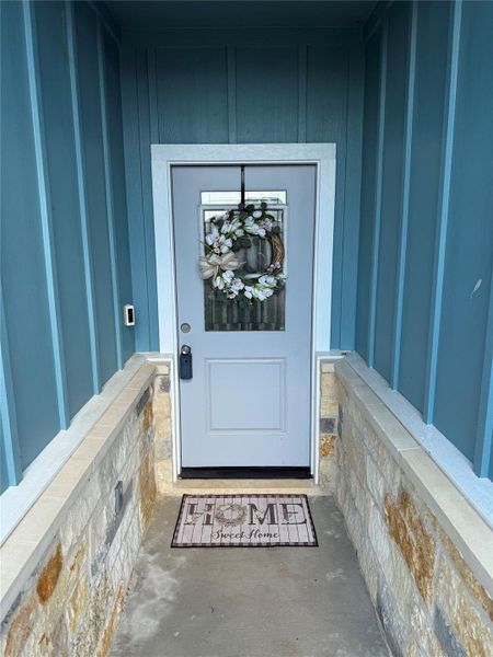 A welcoming front entry awaits with stone details and a neatly framed door. A welcoming front entry awaits with stone details and a neatly framed door.