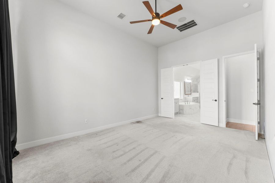 Elegant primary suite with soothing tones, upgraded finishes, high ceilings, and plush carpet. Elegant primary suite with soothing tones, upgraded finishes, high ceilings, and plush carpet.