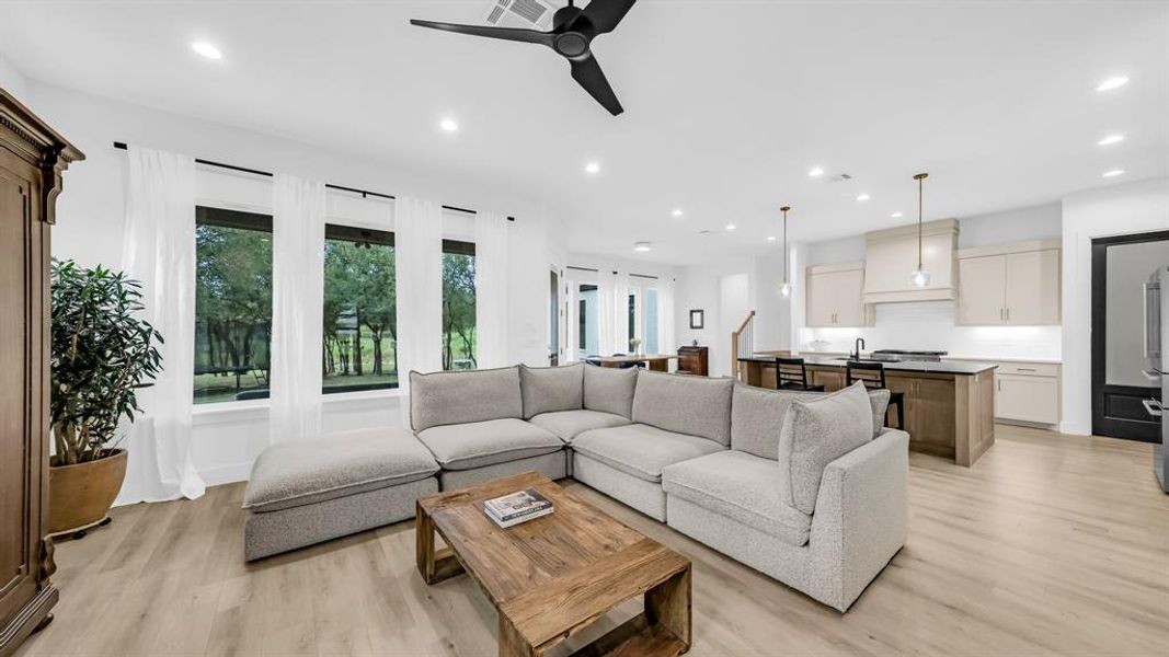 Living area featuring light wood-type flooring, ceiling fan, and recessed lighting Living area featuring light wood-type flooring, ceiling fan, and recessed lighting