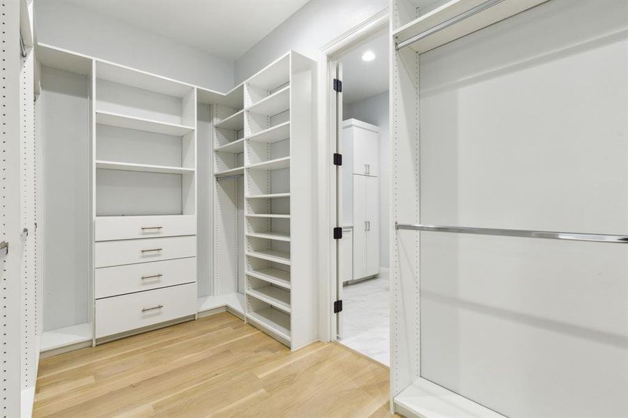 Custom closets in all bedrooms! This is a portion of the primary closet. The doorway leads to the laundry room conveniently accessible from the closet!