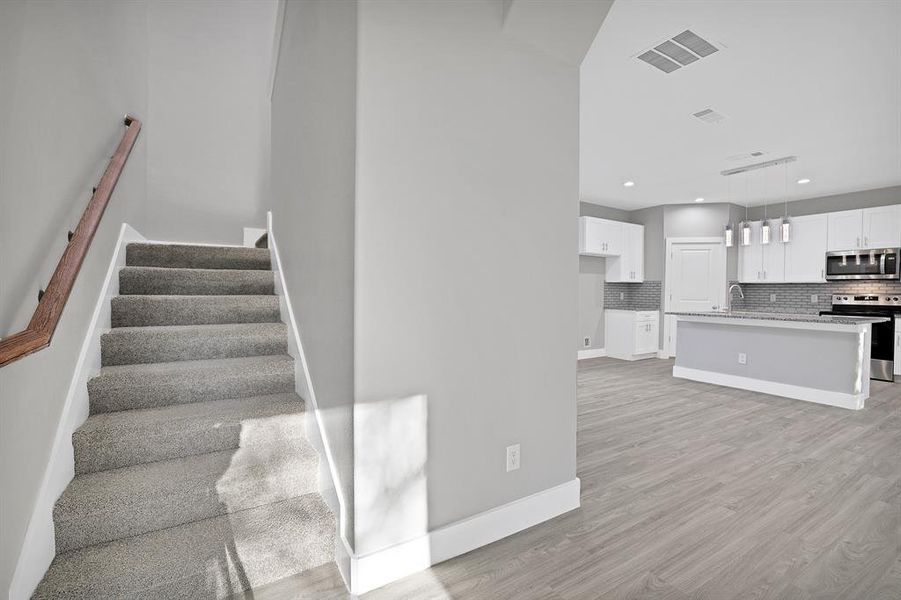 Stairway featuring hardwood / wood-style floors