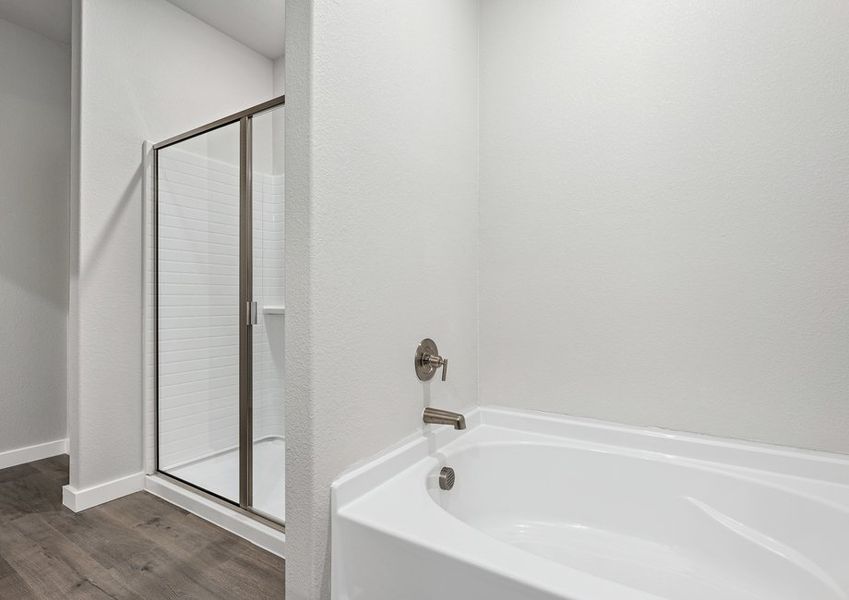 The master bathroom has a garden tub and glass, walk-in shower.