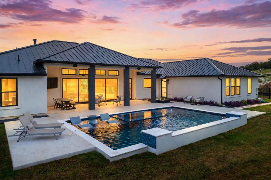 An inviting swimming pool and covered patio highlight the modern rear exterior of this home.