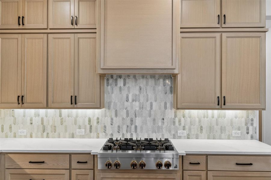 A well-appointed kitchen features a professional-grade gas range set against a stylish tiled backsplash. A well-appointed kitchen features a professional-grade gas range set against a stylish tiled backsplash.