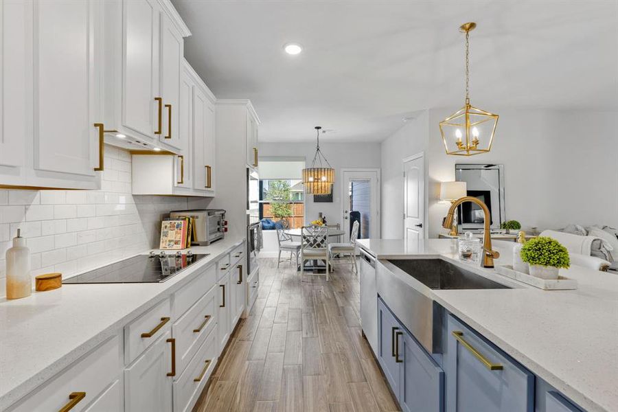 Kitchen with white cabinetry, light stone counters, hanging light fixtures, recessed lighting, and light wood-style flooring