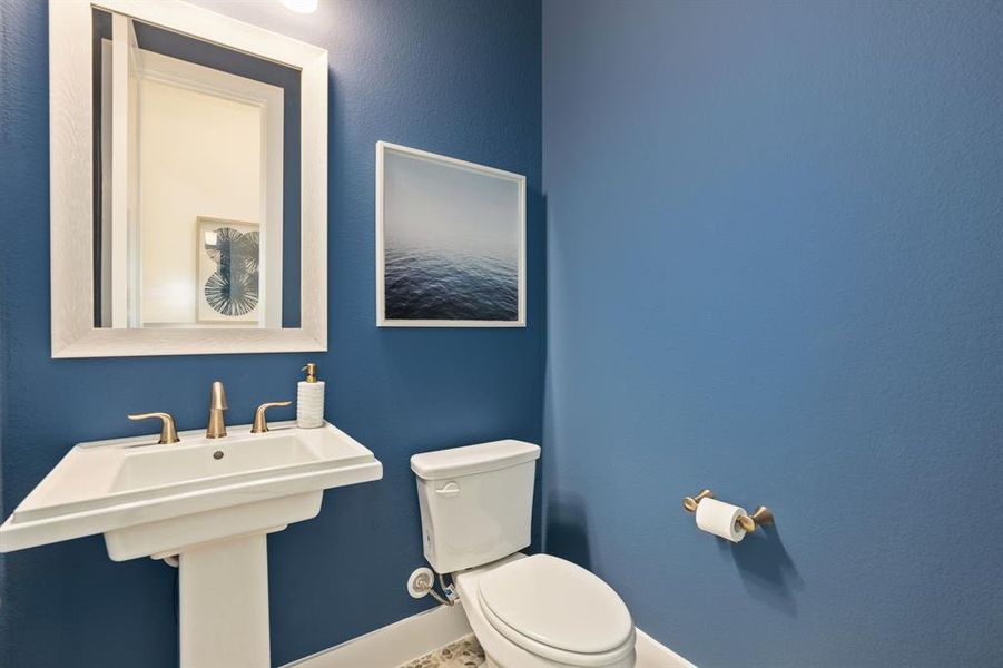 Half bath featuring toilet and baseboards Half bath featuring toilet and baseboards