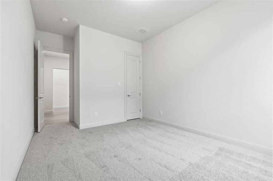 Unfurnished bedroom featuring light colored carpet and baseboards