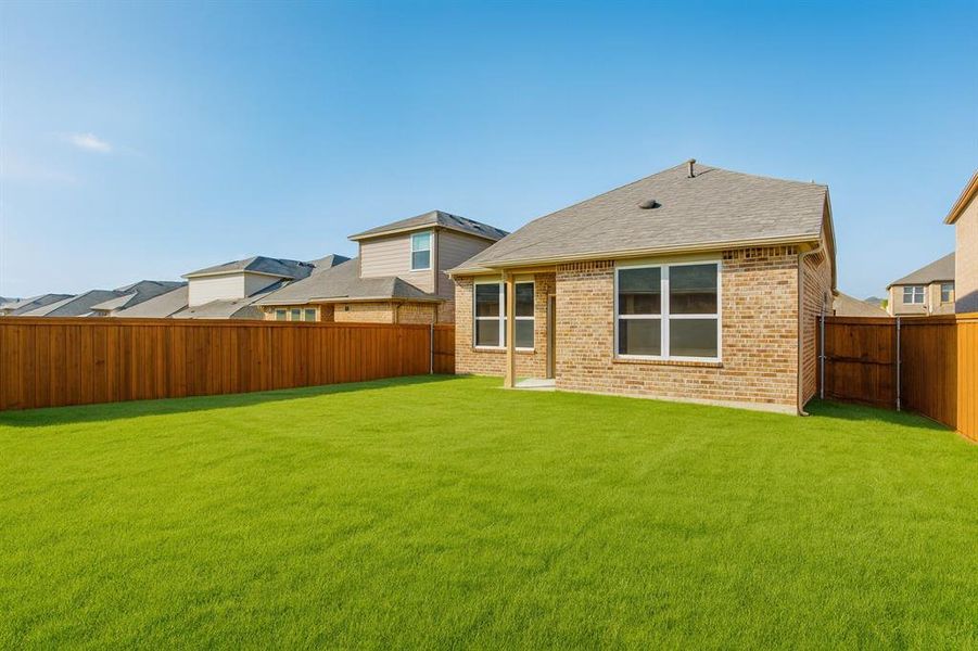 Rear view of property featuring brick siding, roof with shingles, and a fenced backyard Rear view of property featuring brick siding, roof with shingles, and a fenced backyard
