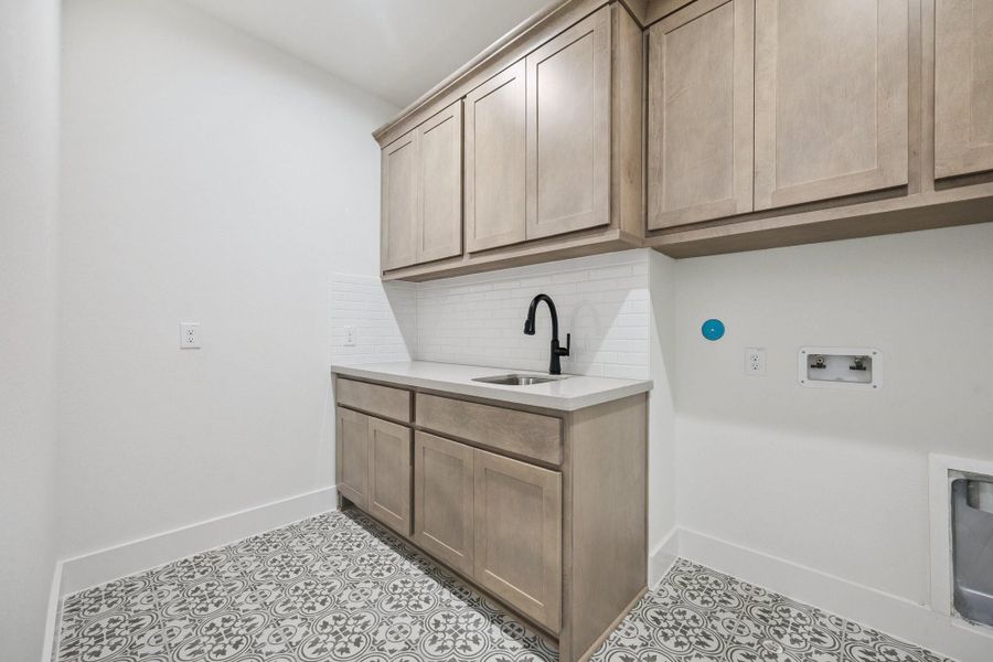 Imagine the ease of doing laundry in this pretty second floor laundry room with soaking sink, storage cabinetry, and folding counter. Imagine the ease of doing laundry in this pretty second floor laundry room with soaking sink, storage cabinetry, and folding counter.