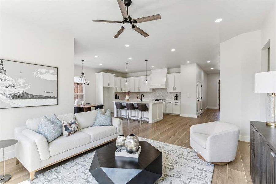 Living room featuring ceiling fan, sink, and light hardwood / wood-style flooring