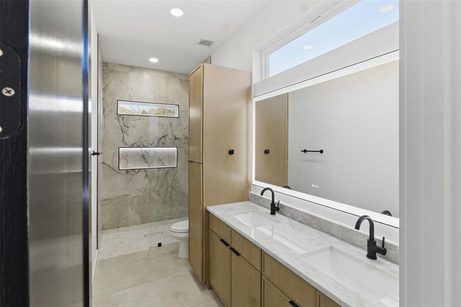 Full bathroom with double vanity, a marble finish shower, and recessed lighting
