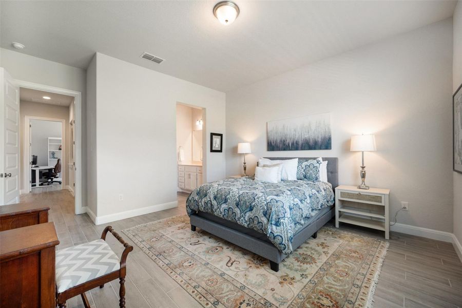Bedroom featuring light wood-type flooring, a desk, and ensuite bathroom