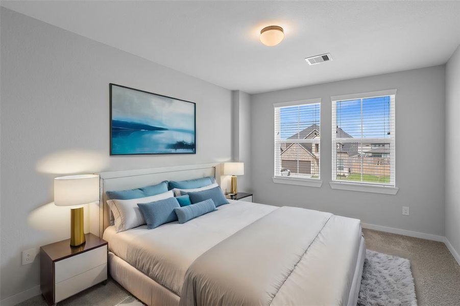 Secondary bedroom features plush carpet, custom paint and a large window with privacy blinds.