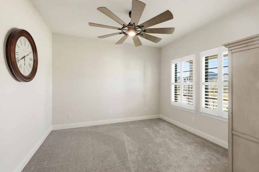 Spare room featuring light colored carpet and ceiling fan