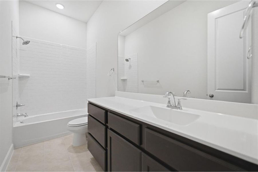 Contemporary bathroom featuring a dark wood-finish vanity with a white countertop and integrated sink