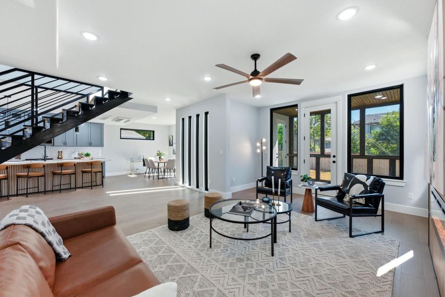 Living area with wood finished floors, stairs, recessed lighting, healthy amount of natural light, and a ceiling fan Living area with wood finished floors, stairs, recessed lighting, healthy amount of natural light, and a ceiling fan