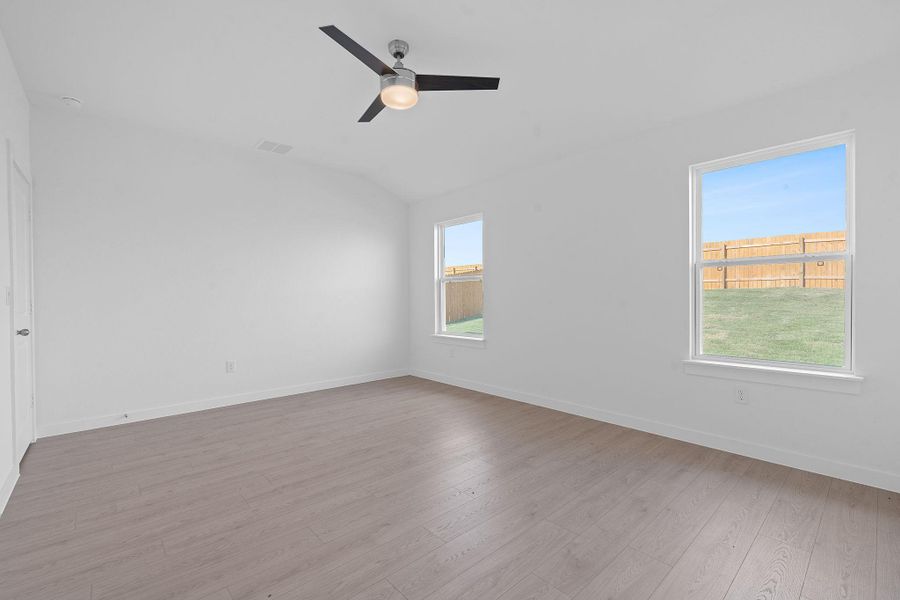 Unfurnished room with light wood-style floors, ceiling fan, and vaulted ceiling