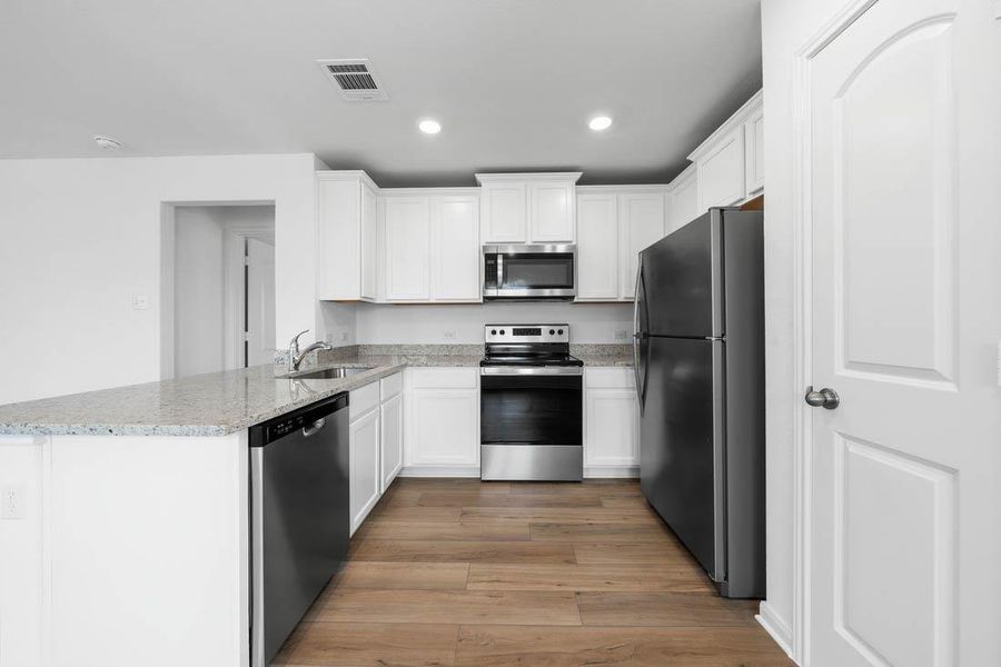 Gleaming stone countertops and stainless steel appliances anchor this beautifully designed modern kitchen.