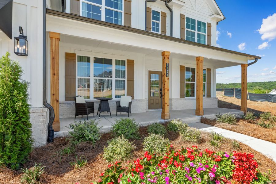 A house with a patio and a flower bed. A house with a patio and a flower bed.