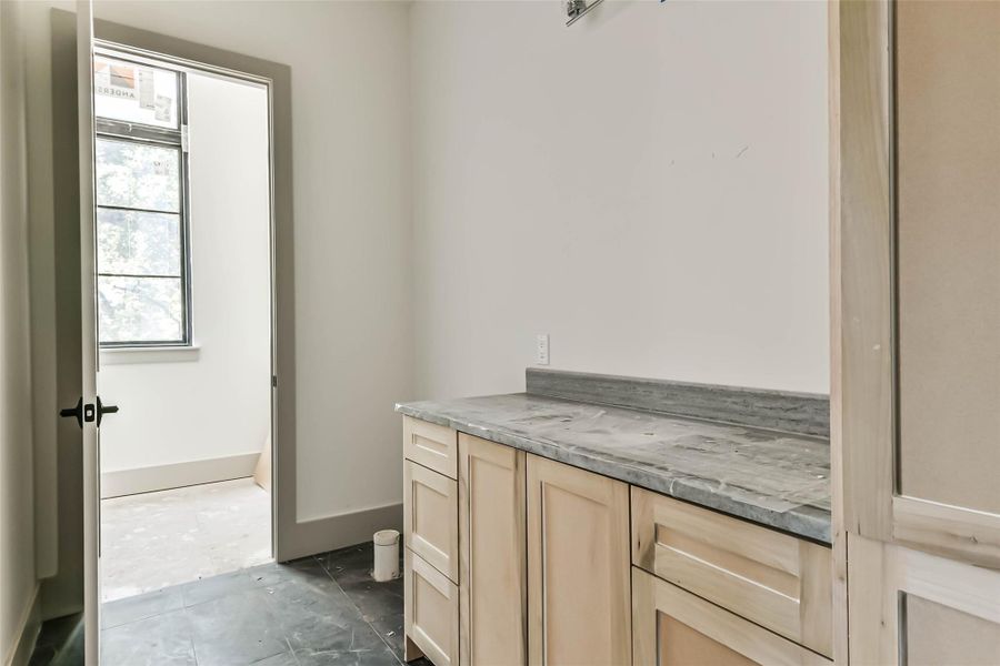 This en-suite bath, with quartzite countertops, custom cabinets, and shower, is located off the first floor study with a walk-in closet. This progress photo was taken May 26th.