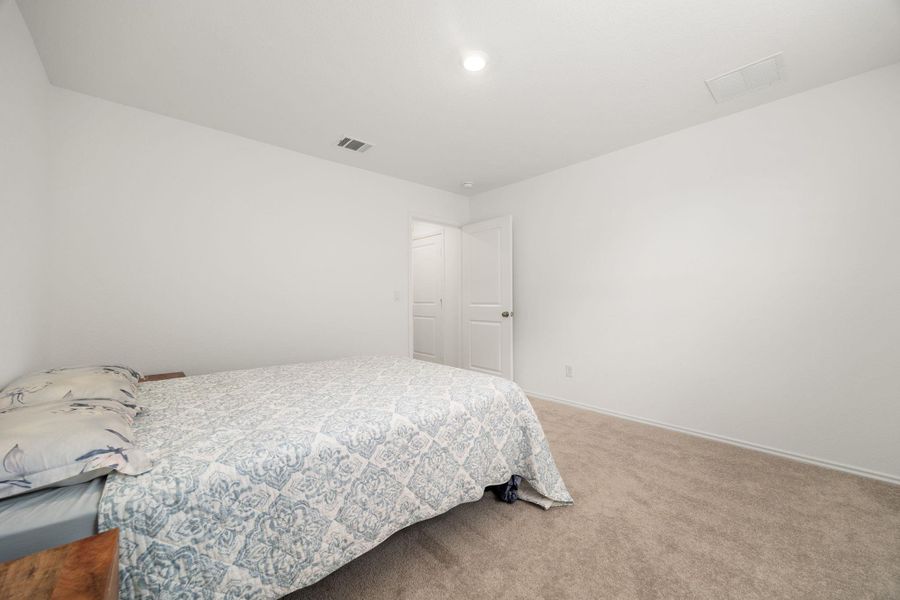 A well-lit bedroom offering a restful retreat with soft carpeting underfoot.