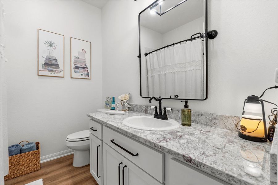 The spa-like primary bath features dual vanities, granite countertops, designer lighting and elegant finishes that blend style with everyday comfort