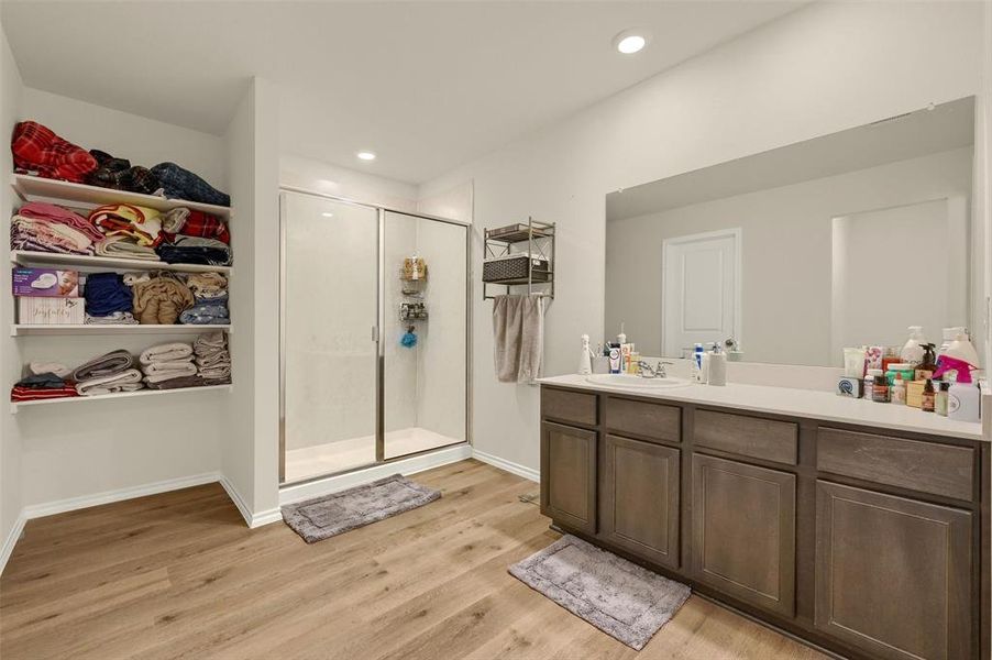 Bathroom with vanity, wood-type flooring, and an enclosed shower