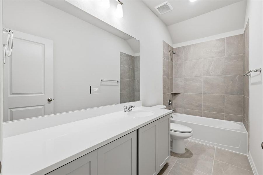 Full bath featuring vanity, light tile patterned floors, and bathtub / shower combination