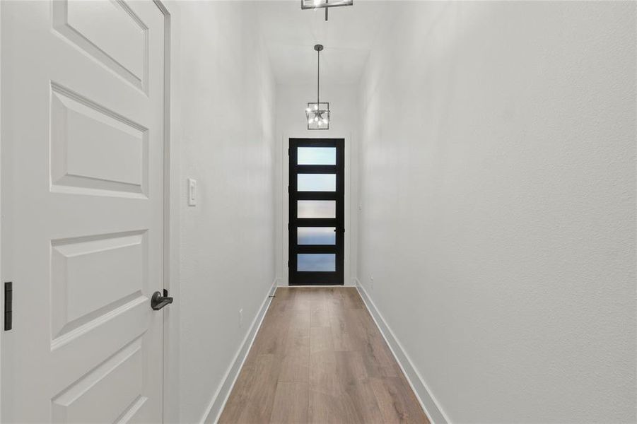 Doorway to outside with baseboards and wood finished floors