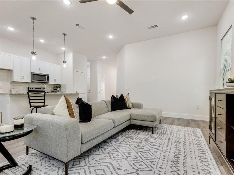 Living area with light wood-type flooring, recessed lighting, and a ceiling fan