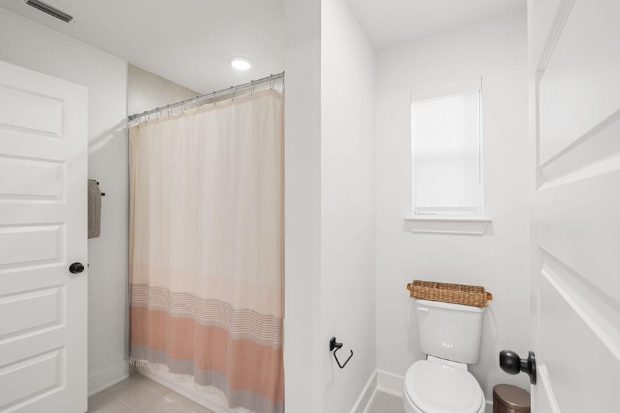 Full bathroom featuring white paneled doors, a shower with a shower curtain, and a toilet Full bathroom featuring white paneled doors, a shower with a shower curtain, and a toilet