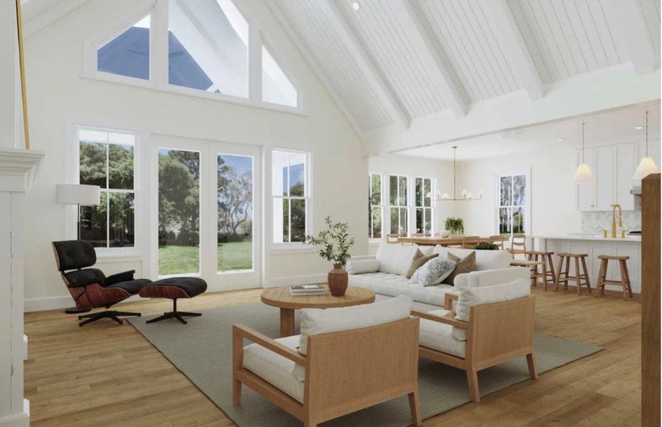 A spacious living area features high vaulted ceilings and hardwood flooring, offering serene views of the outdoor landscape.