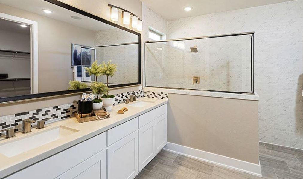 Bathroom with backsplash, a tile shower, a sink, and double vanity Bathroom with backsplash, a tile shower, a sink, and double vanity