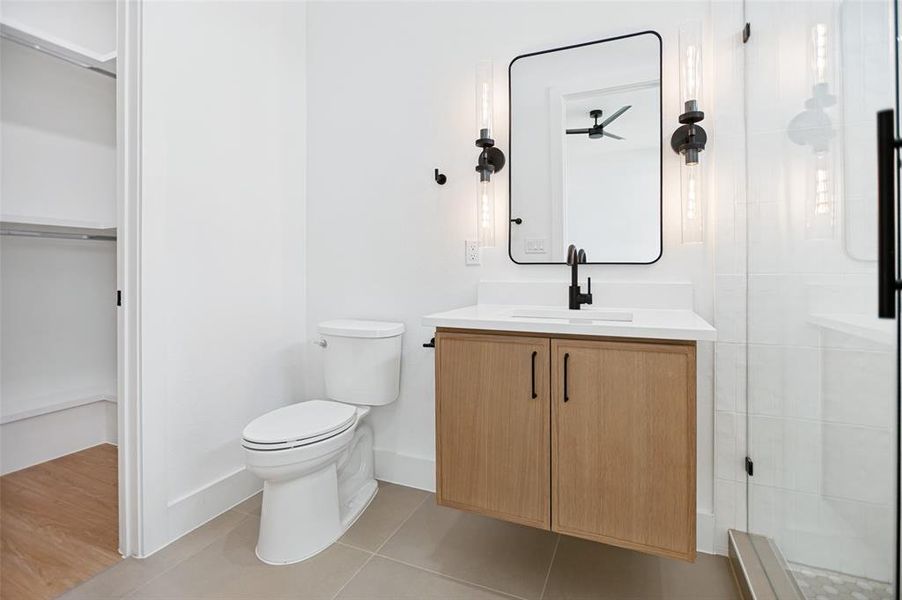Bathroom featuring a floating wood-finish vanity with a white countertop and rectangular sink