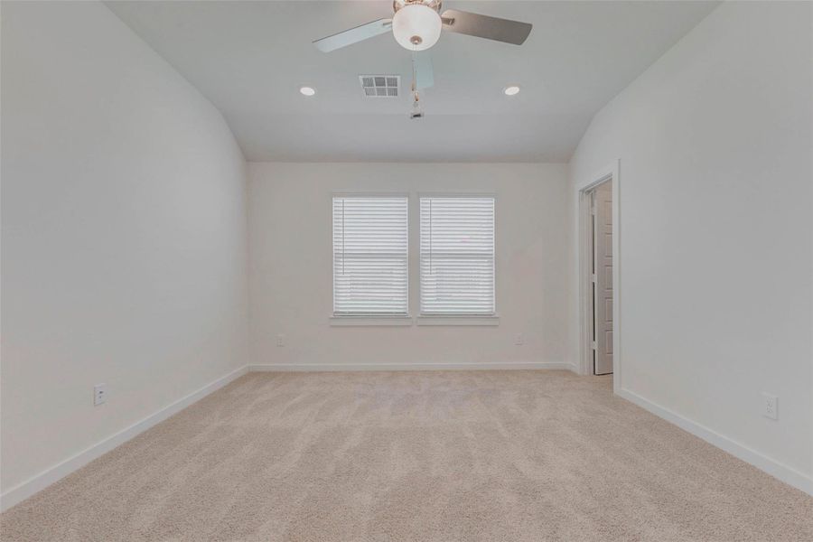 Clean lines and calming tones define this peaceful primary suite. Recessed lighting and a modern ceiling fan enhance the space, while two full-size windows provide abundant natural light. With private access to the en suite bath, this room blends function and comfort in perfect balance.