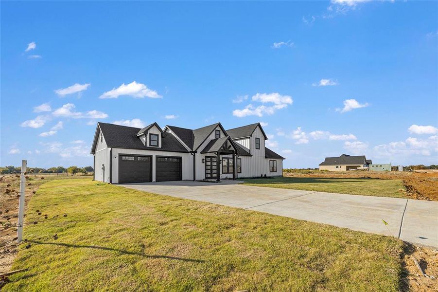 View of front of property with a front lawn and a garage