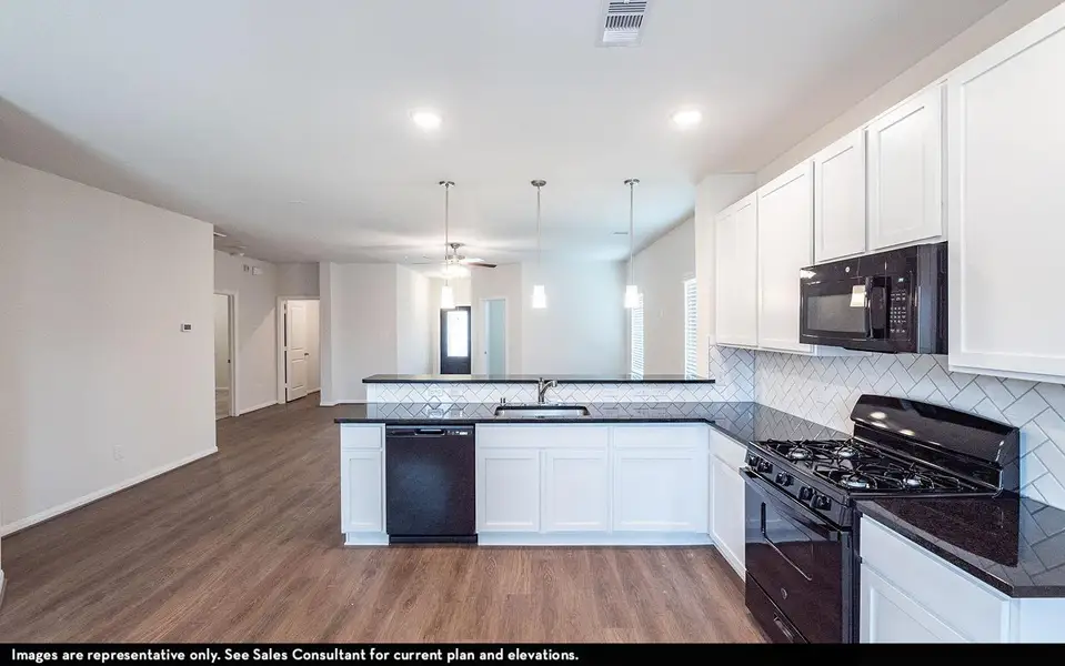 Kitchen with visible vents, a sink, black appliances, and wood finished floors