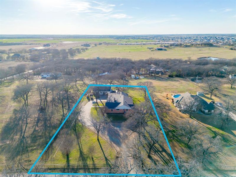 Aerial view of sparsely populated area with property parcel outlined