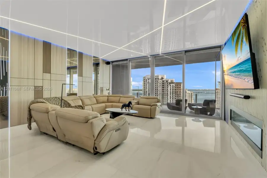 Floor-to-ceiling sliding glass doors, linear LED ceiling lighting, custom wall paneling, high-gloss tile flooring, and integrated linear fireplace Floor-to-ceiling sliding glass doors, linear LED ceiling lighting, custom wall paneling, high-gloss tile flooring, and integrated linear fireplace