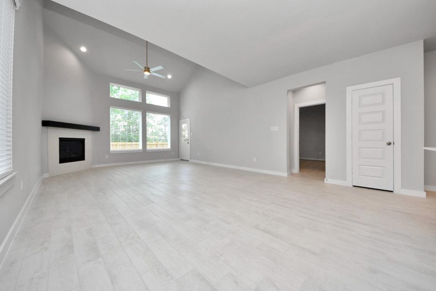 Family room flooded with natural light through the expansive windows.  The premium tile flooring adds a touch of luxury to the space, creating the perfect setting for relaxing moments and cherished gatherings with loved ones.