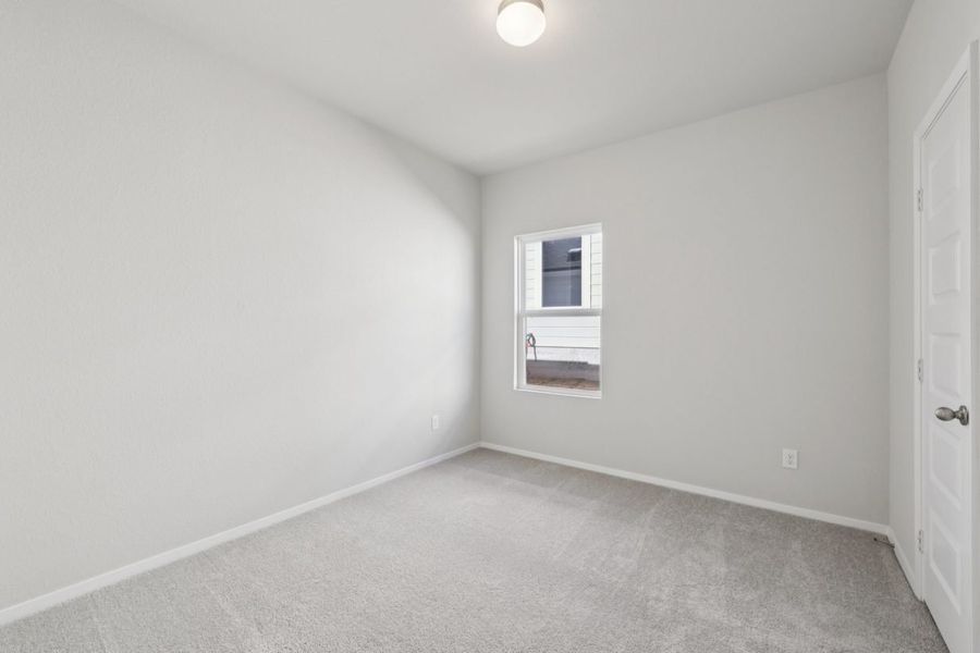 Image of a bedroom with light grey walls and a window