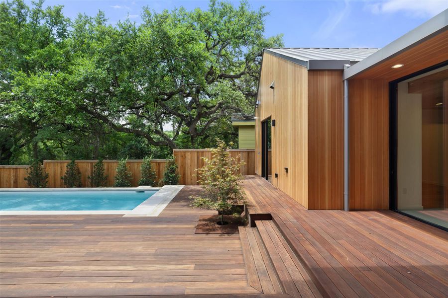 View of swimming pool featuring a wooden deck and a fenced backyard