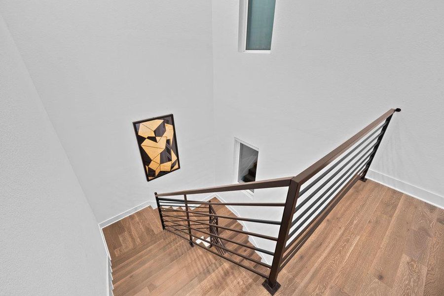 Stairway with wood finished floors and baseboards